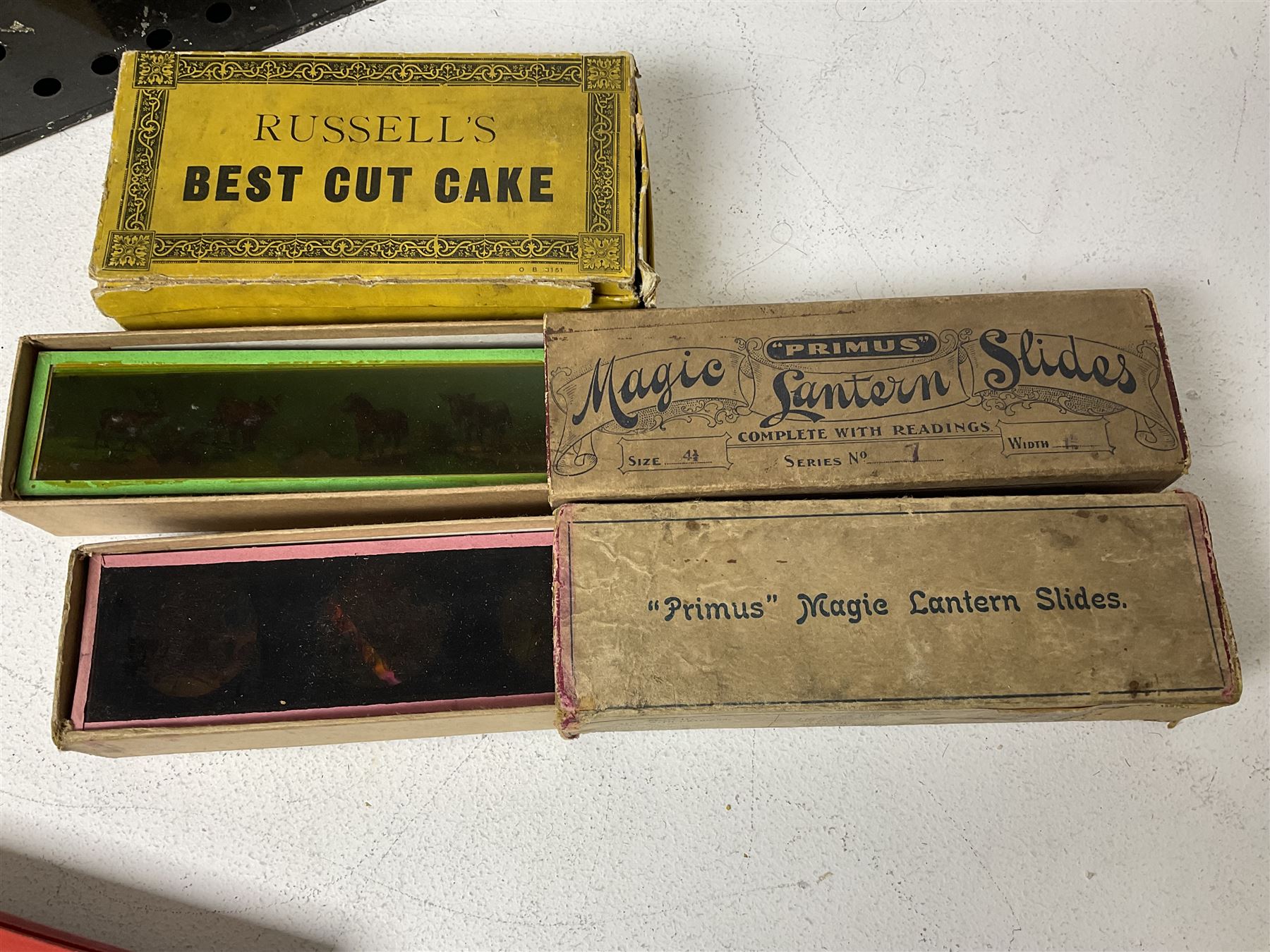 Tinplate magic lantern with three boxes and some loose slides, including Primus magic lantern slides