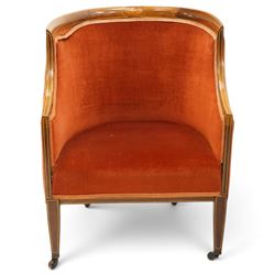Pair of Edwardian inlaid mahogany tub armchairs, traditional shape with satinwood stringing, upholstered in crimson fabric with sprung seat, on square tapering supports with castors