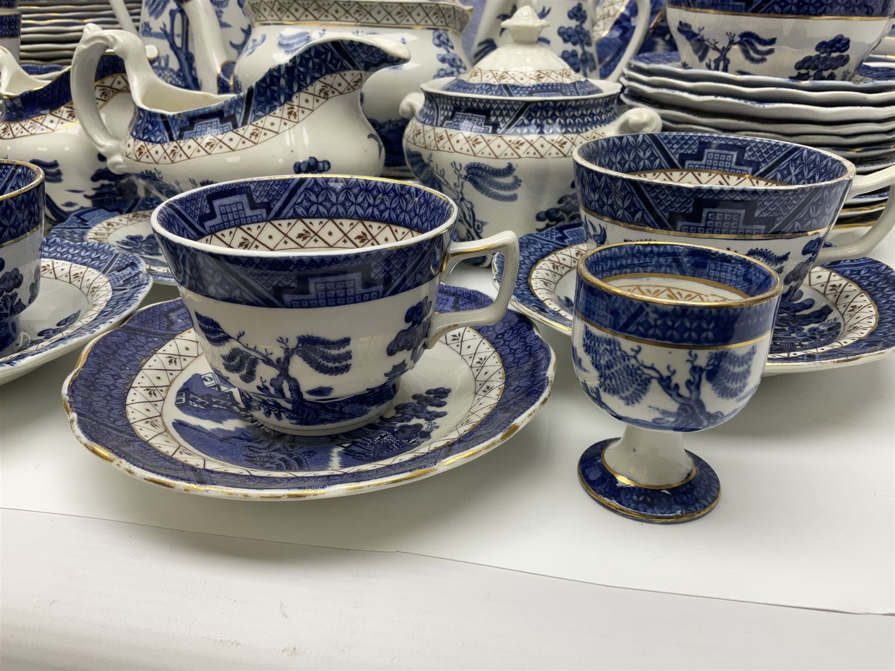 Booths Real Old Willow pattern part tea and dinner service, to include two meat platters, cake stand, teapot, two jugs, sugar bowl, sauce boat, teacups and saucers and a collection of plates and bowls