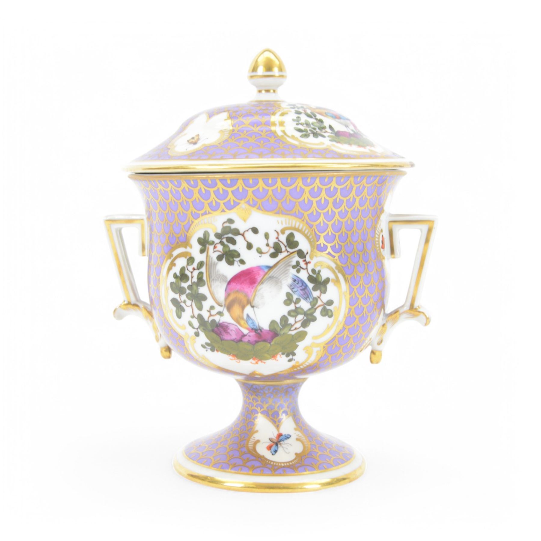 19th century twin handled cup and cover, the pedestal cup decorated with panels of exotic plumed birds in the manner of Giles, against a purple and gilt scale ground, the cover similarly decorated, H19cm