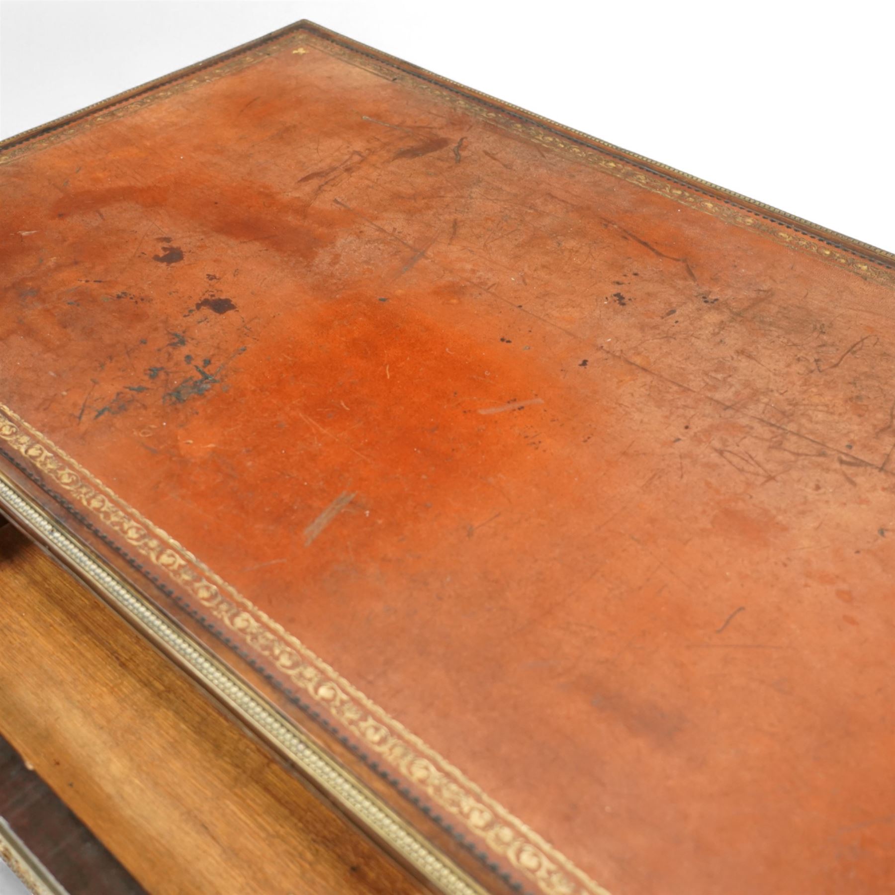 Fine 19th-century Louis XVI-style mahogany and gilt bronze-mounted writing table, rectangular top with a gilt tooled tan leather writing surface within a moulded gilt bronze edge above a frieze fitted with three drawers, mounted with floral and foliate gilt bronze swags  and borders, raised on square tapering legs with acanthus mounts and toupie feet
