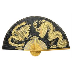 Chinese fan of large proportion decorated with gilt dragons on black ground, L90cm