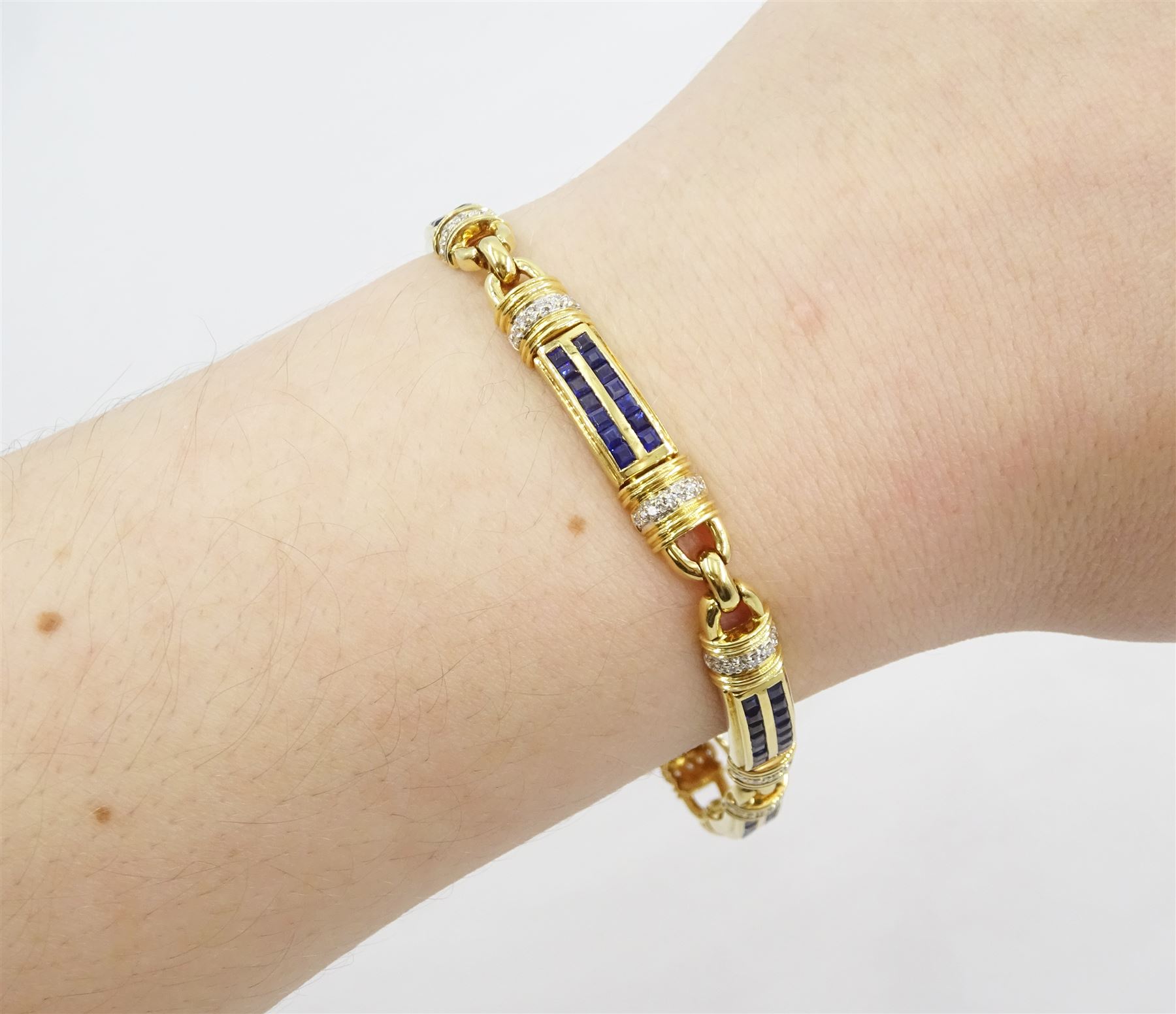 18ct gold sapphire and diamond bracelet, each link set with two rows of rectangular step cut sapphires, with pave set diamonds either side, stamped, total diamond weight 0.40 carat, total sapphire weight 2.50 carat, with World Gemological Institute report