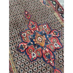 Persian Hamadan rug, the rosette pole medallion on a pale field decorated with stylised motifs, the blue band border decorated with stylised flower heads