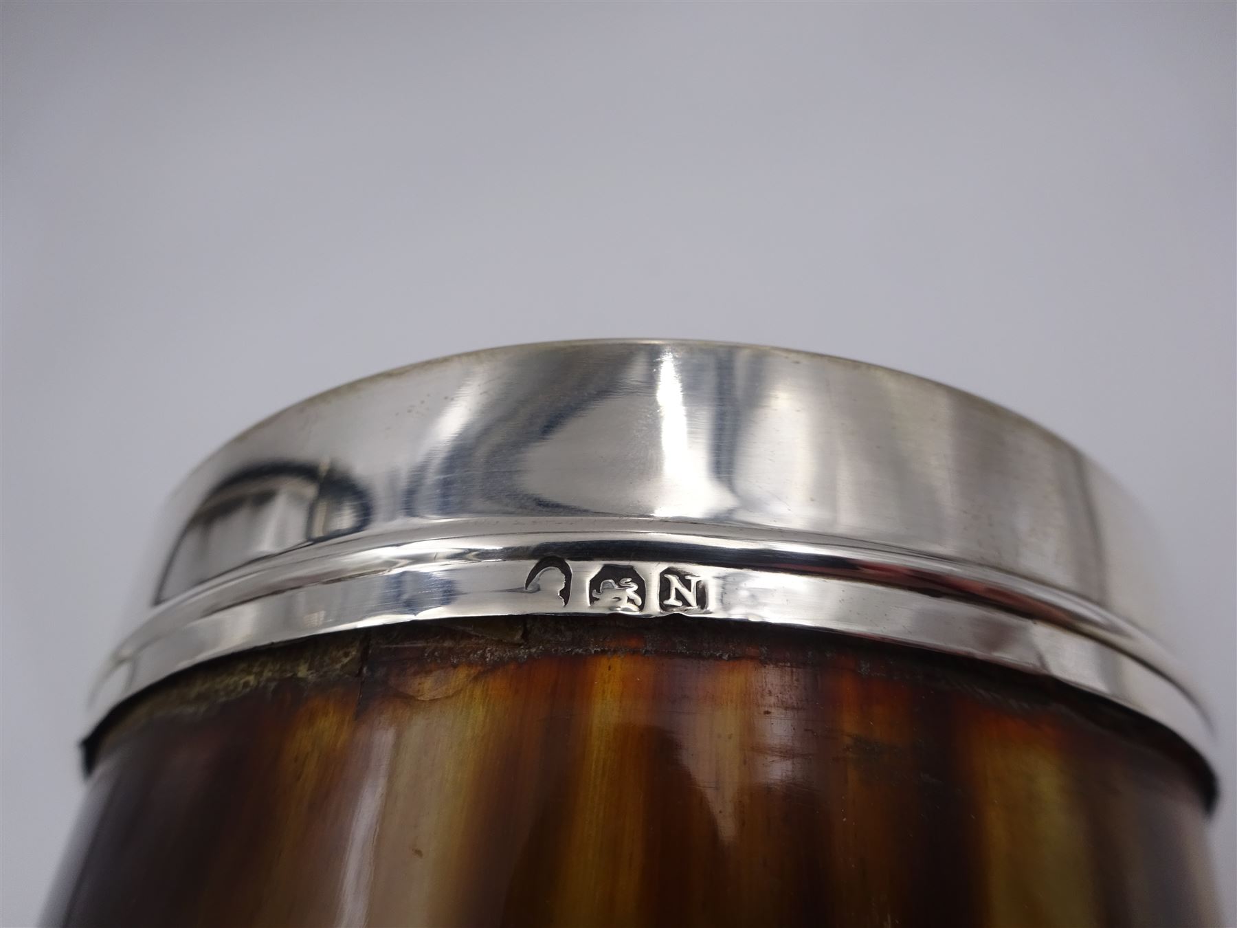 George III silver mounted horn cup, of tapering circular form, with polished exterior, the silver mounted collar hallmarked London 1808, no visible assay or makers mark, H13.5cm