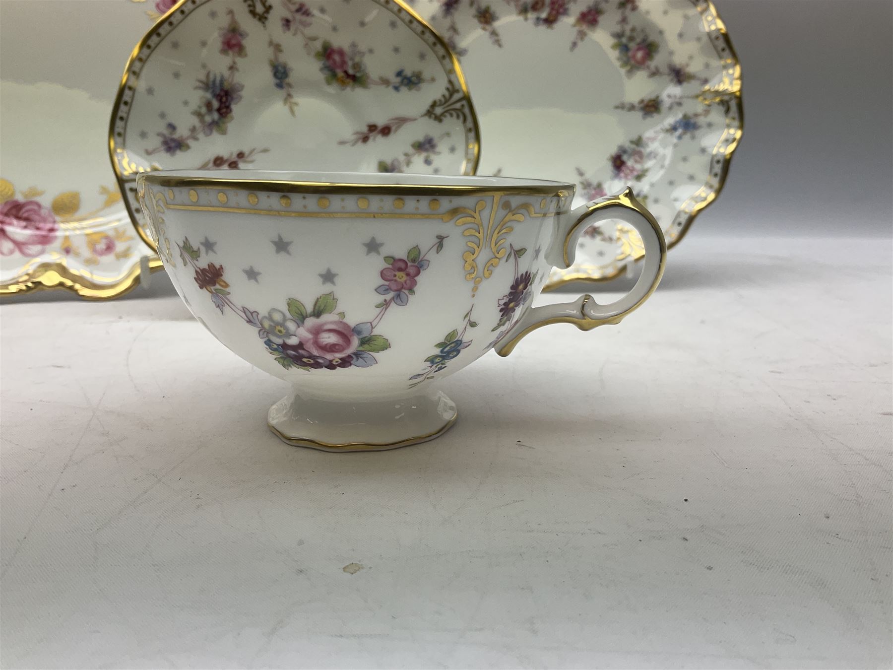 Coalport Revelry pattern tea and dinner wares, comprising nine dinner plates, four salad plates, eleven side plates, sauce boat and stand, ten teacups and ten saucers, and preserve pot and cover, together with a Coalport plate of shaped form decorated with pink roses, and a Royal Crown Derby Royal Antoinette pattern trio