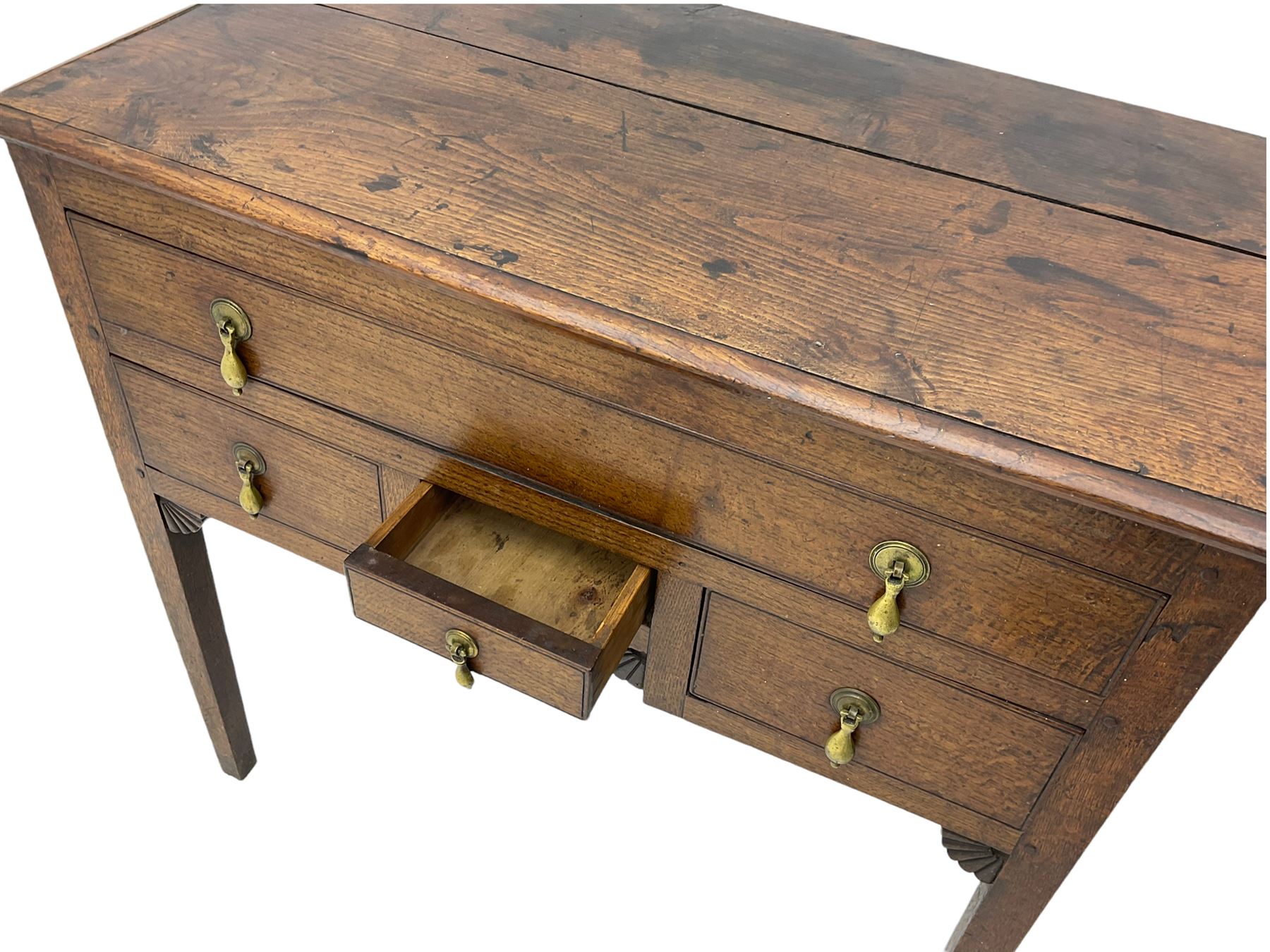 18th century Welsh oak lowboy, fitted with long drawer above three small drawers, square tapering supports, with fan carved corner brackets, circular plate and drop handles 