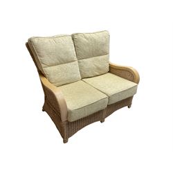 Contemporary rattan conservatory suite - two seat sofa with wicker frame and loose cushions upholstered in textured champagne fabric (W125cm H98cm); pair of matching armchairs (W72cm H98cm); rectangular glass-topped coffee table with rattan frame and undertier (W85cm D60cm H47cm); and matching square side table (W53cm H55cm)