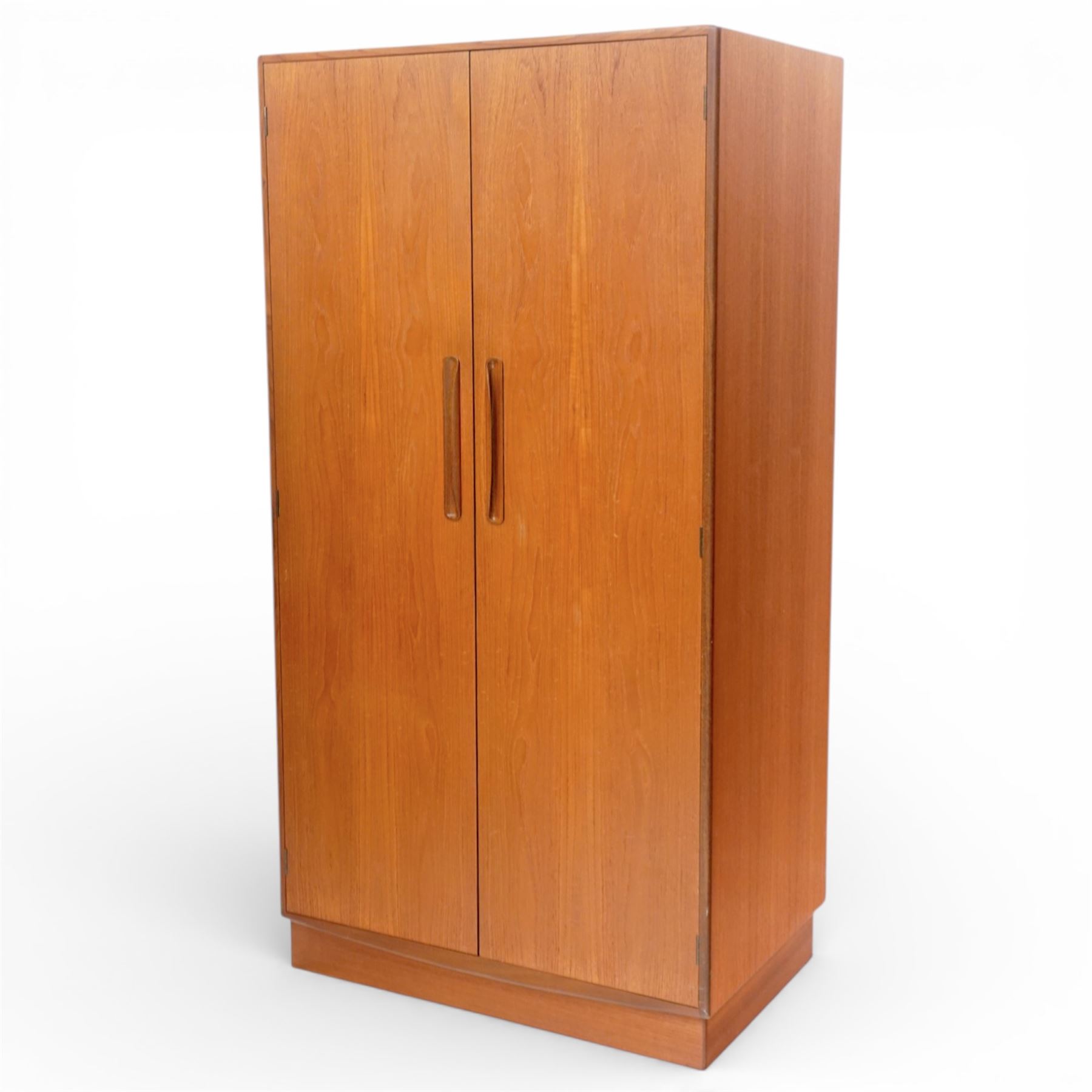 G Plan - 'Fresco' teak double fitted gentleman's wardrobe, twin doors enclosing two sections, a single clothes rail and drawers and shelving, on a recessed plinth base