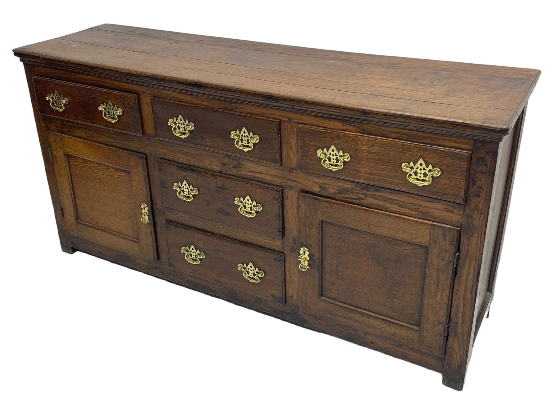 George III country oak dresser base,  rectangular top over with three central drawers flanked by two drawers and two panelled cupboards, each with moulded fronts, on stile feet