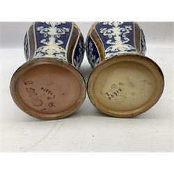 Pair of Royal Doulton Lambeth stoneware baluster vases, decorated in light relief with panels of foliage on blue ground, with gilt scrolls above, impressed mark beneath, 28cm high