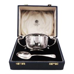 Modern silver christening bowl and spoon, the bowl of plain circular form, with twin caryatid scroll handles, including handles H6.4cm D10.1cm, both hallmarked Mappin & Webb Ltd, Sheffield 1964, contained within a velvet and silk lined fitted case, approximate total silver weight 5.16 ozt (160.3 grams) 