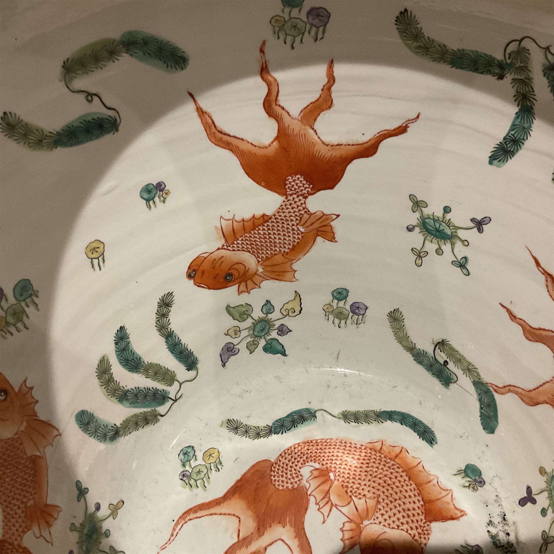 Large 20th century Chinese famille noir glazed porcelain jardinière, of ovoid form, the exterior enamelled with butterflies and white cranes amidst blossoming water lilies and pads against a black ground, between two stylised polychrome borders and beneath a key border to rim, the interior enamelled with red koi fish swimming amongst water fronds and weeds, with printed red character mark beneath, the whole upon an ebonised hardwood stand with three cabriole legs, jardinière H42cm D47cm, including stand overall H69.5cm