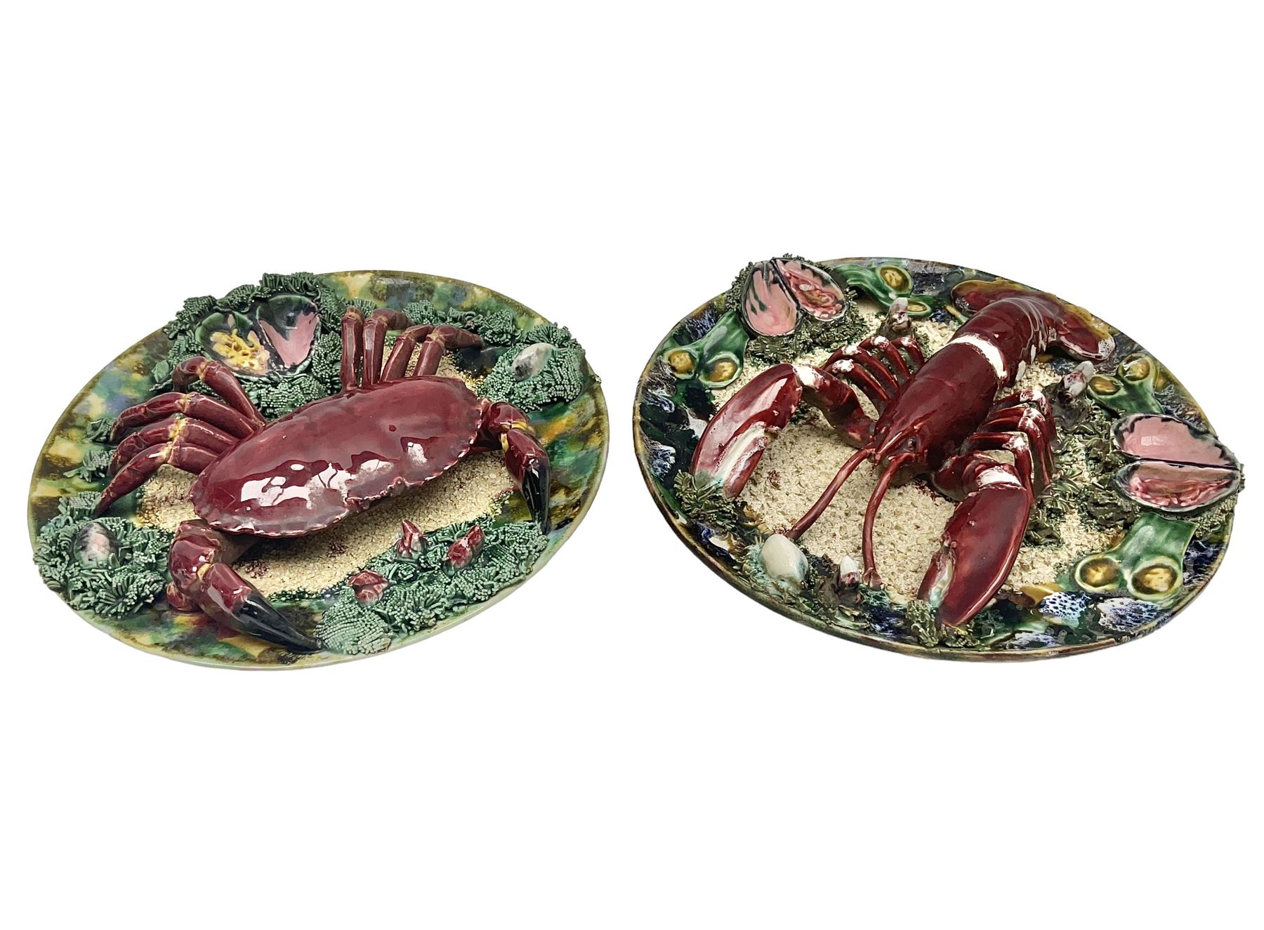Two 20th Century Portuguese Palissy style Majolica wall plates, one depicting a crab, the other a lobster each to the centre modelled in relief surrounded by encrustations and shells, both with impress marks beneath, D34cm