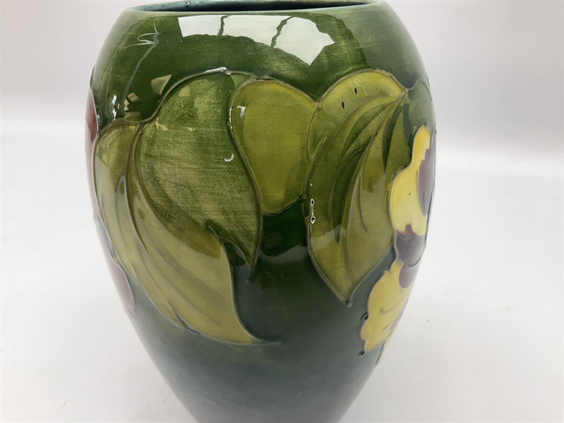 Moorcroft Hibiscus pattern vase of ovoid form, decorated with pink, yellow and purple flowers on merging blue and green vase, with impressed and painted marks beneath, H18cm