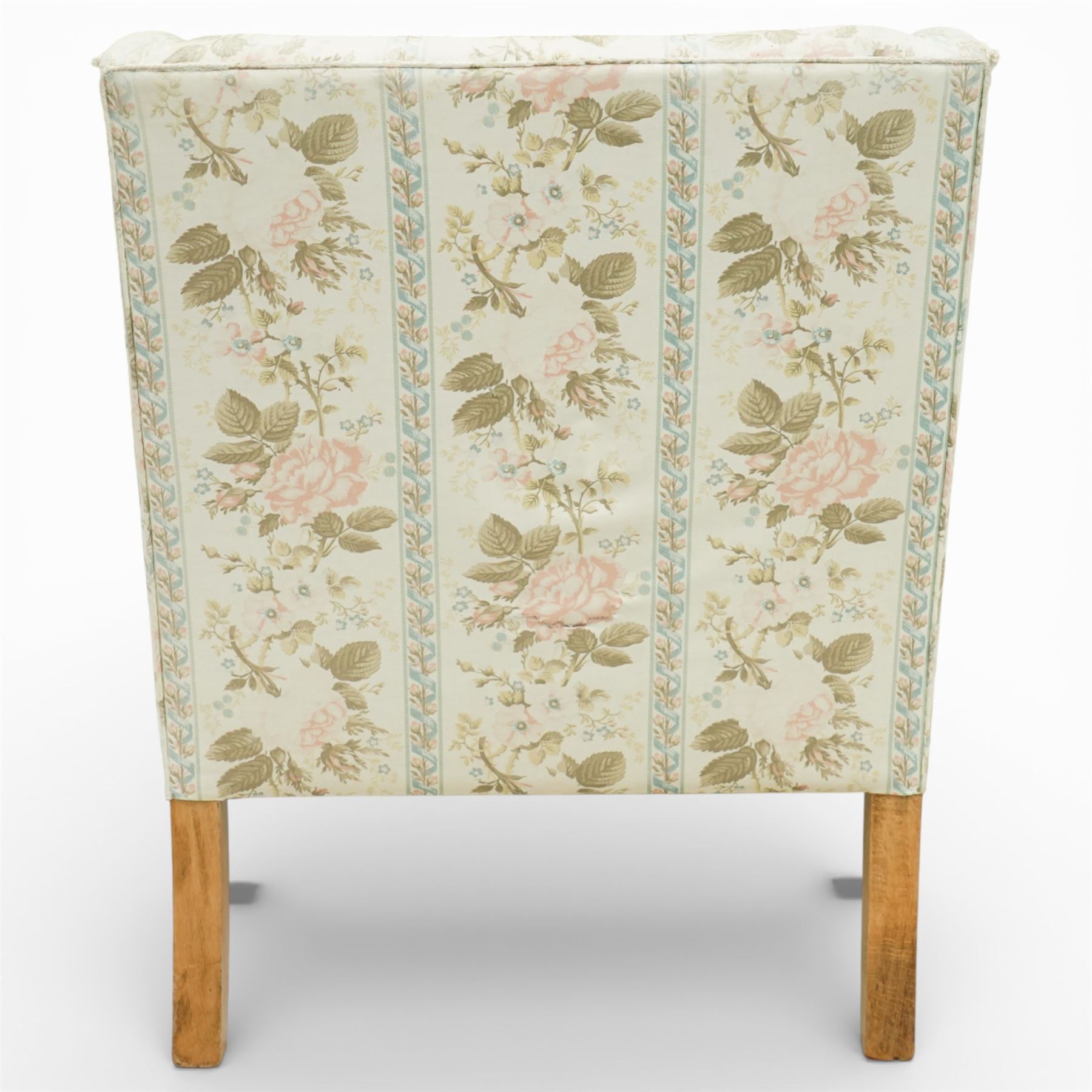 Pair of Edwardian upholstered armchairs, each with shaped padded back flanked by scroll arms, loose seat cushions, upholstered throughout in rose patterned fabric with vertical floral bands, raised on square tapering wooden legs