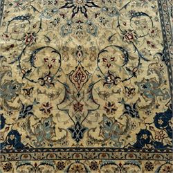 Nain Persian rug, hand knotted with a central medallion surrounded by a symmetrical arrangement of floral motifs, arabesques, curvilinear vines on an ivory background with teal and burgundy colours 