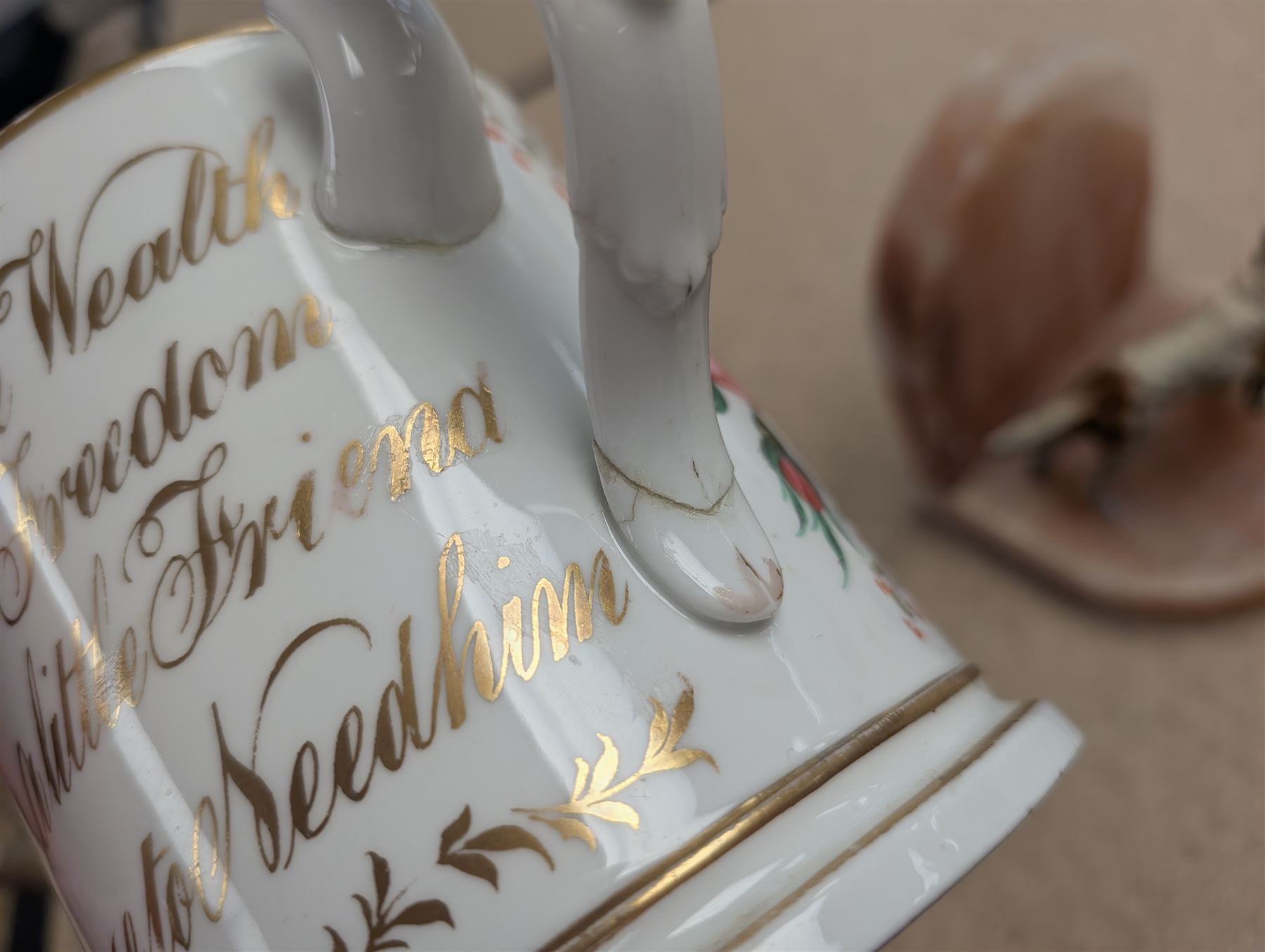 Pair of Art Deco dog bookends and a twin handled loving cup, painted with floral decoration and quote, loving cup H14cm