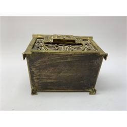 An Arts and Crafts brass and leather casket, decorated with scrolling tendrils and stylised buds or fruits, H8cm L12.5cm D9cm