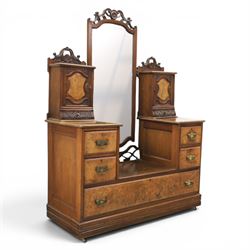 Edwardian figured walnut dressing chest, with central tilting mirror with pierced fret work, flanked by cabinet with figured walnut panelled door above a trinket drawer, with four short over a long long drawer, raised on a plinth base with castors 
