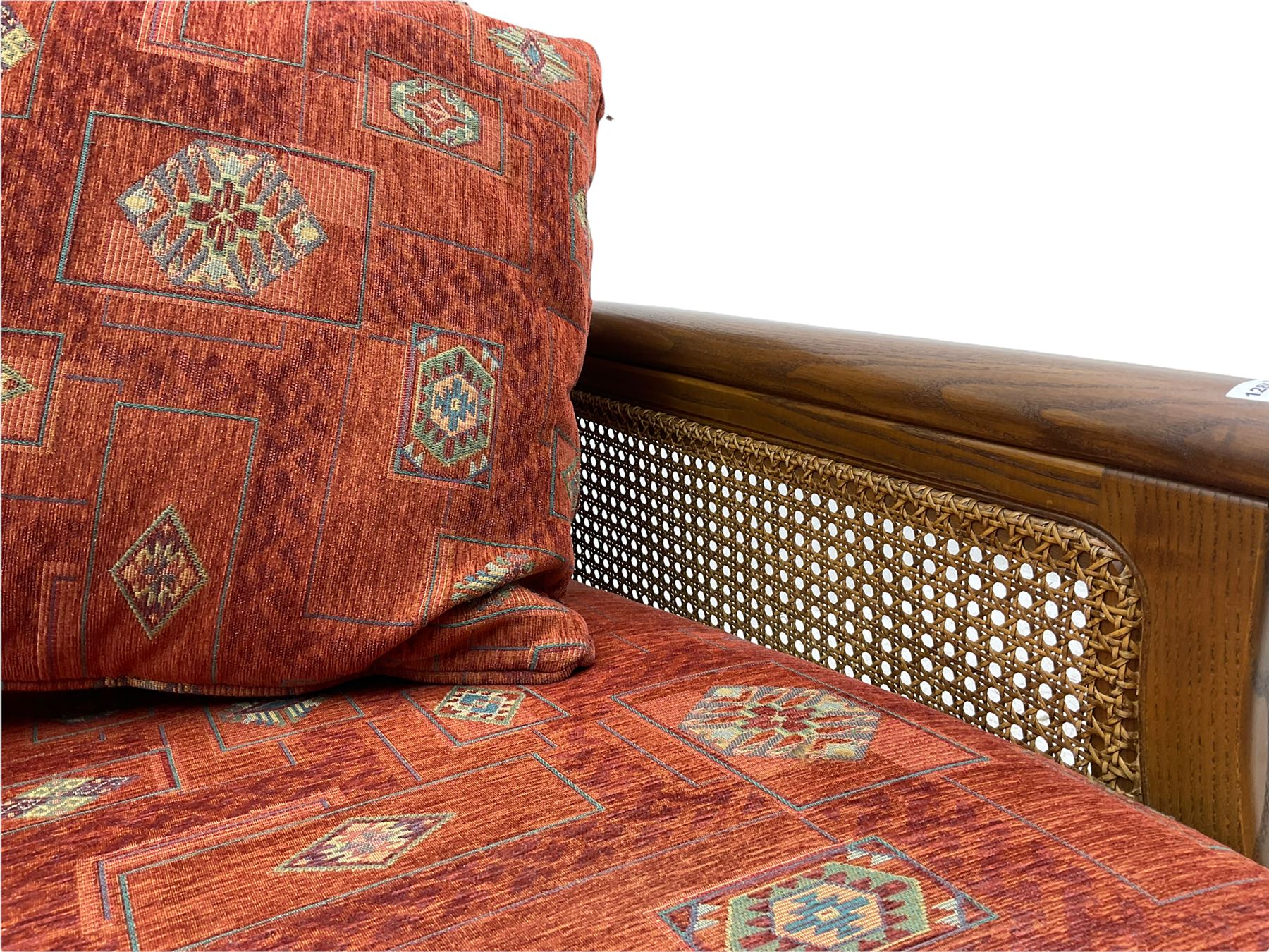 Ercol medium elm framed three seat bergere sofa, and pair of matching armchairs upholstered in red fabric