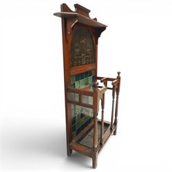 Shapland & Petter of Barnstaple - Arts & Crafts mahogany tile-backed umbrella or stick hall-stand, model no.114, the shaped back with single shelf over an Art Nouveau embossed patinated copper panel and turquoise tiled back, with turned supports and dividers over inset metal drip tray

Notes: A comparable Shapland & Petter stick stand of this model is recorded in Daryl Bennett, Shapland & Petter Ltd of Barnstaple, Museum of Barnstaple and North Devon, p.84, cat. no.5.37, and the model is also listed in Bennett, Liberty’s Furniture 1875-1915, p.298, cat. no.8.6. Examples of this model are known to have been retailed by Liberty & Co.
