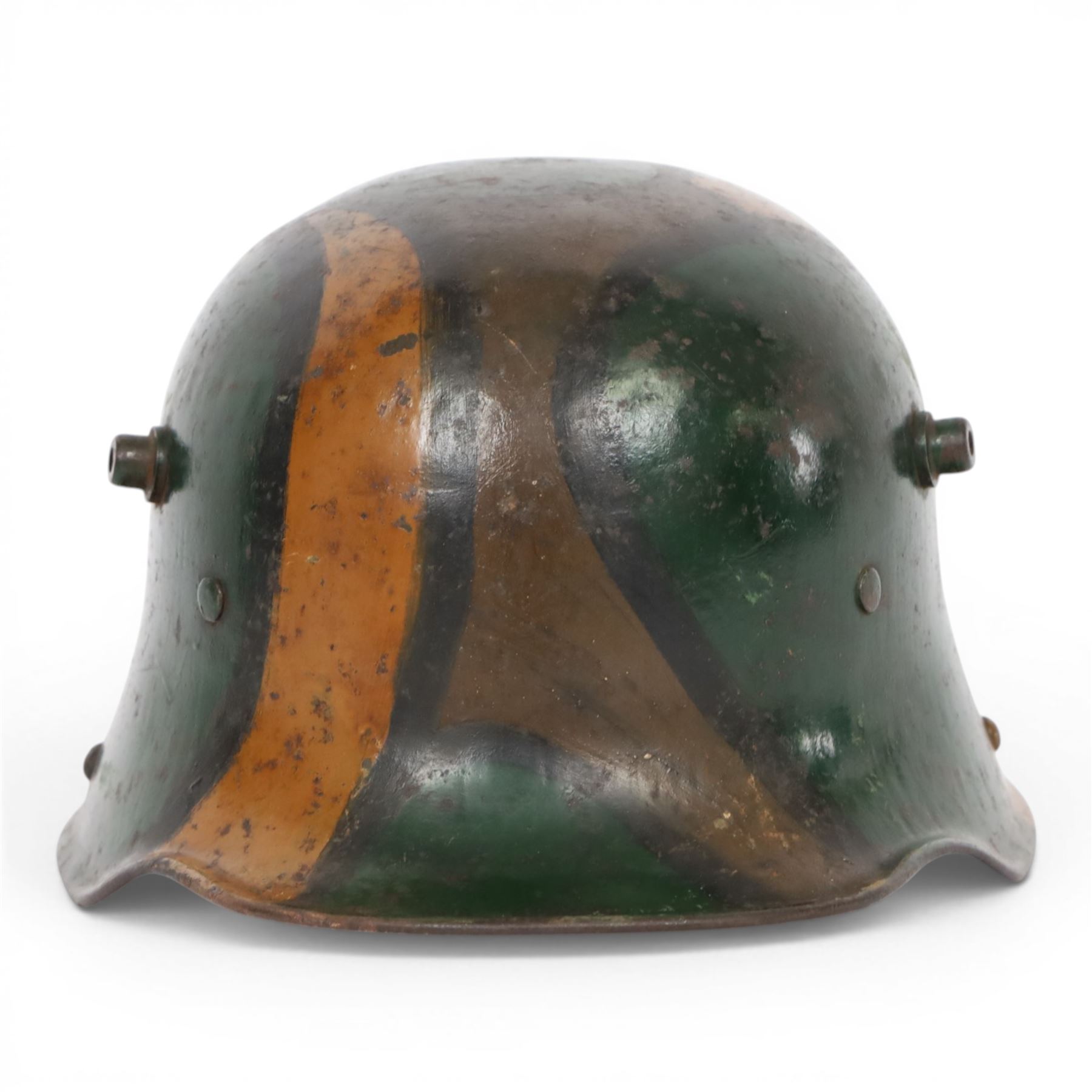 WWI German camouflage M17 helmet, with camouflage painted finish to the skull in green, brown and ochre colours with black separation lines, the interior with leather band which supports three pad leather lining, the pads stamped with indistinct marks 