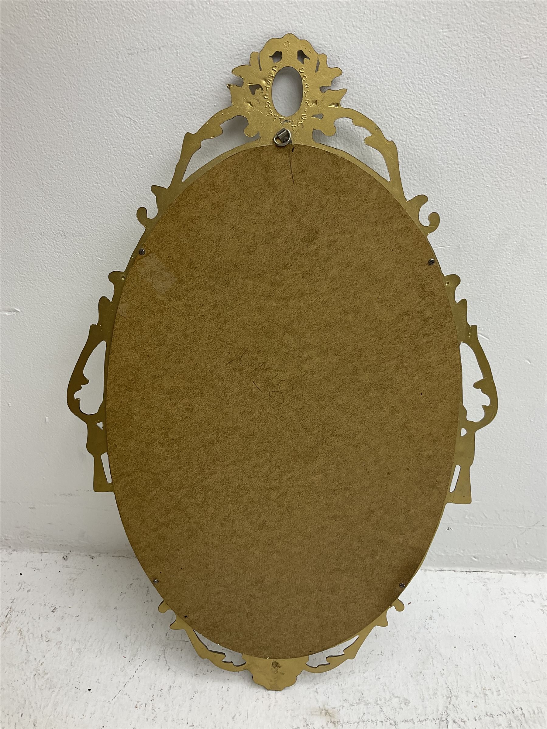 Ornate brass wall mirror with oval plate, L78cm