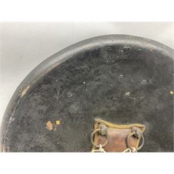 Indian black lacquered hide shield/dhal, of circular convex form with strongly outward-turned brim, fitted at its centre with four metal bosses, each of hemispherical form, with traces of silvered foliate decoration, the bosses corresponding on the inside with four iron rings for enarmes D49cm
