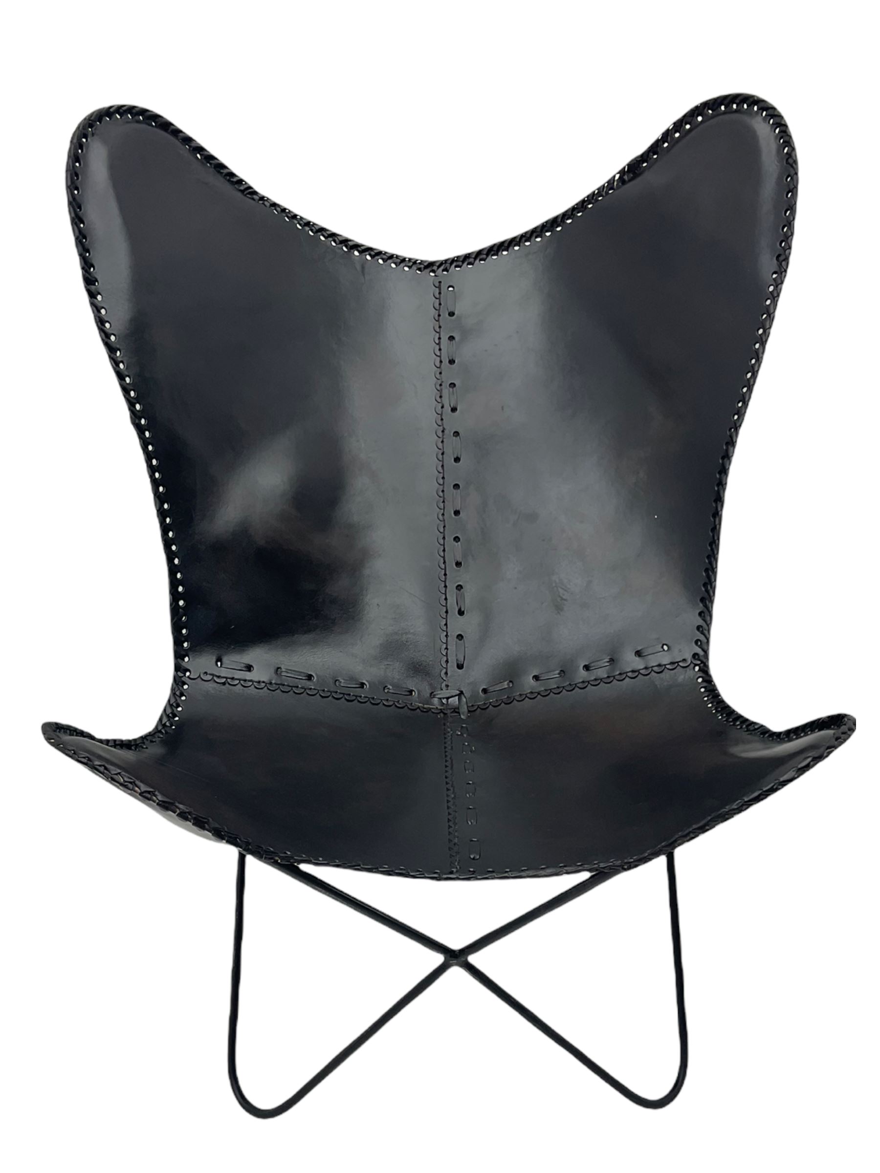 Metal framed butterfly chair upholstered in slung dark tan stitched leather 