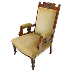 Pair of late Victorian mahogany carved open armchairs, with carved cresting rail, above upholstered seat, back and arms, raised on turned supports terminating in castors