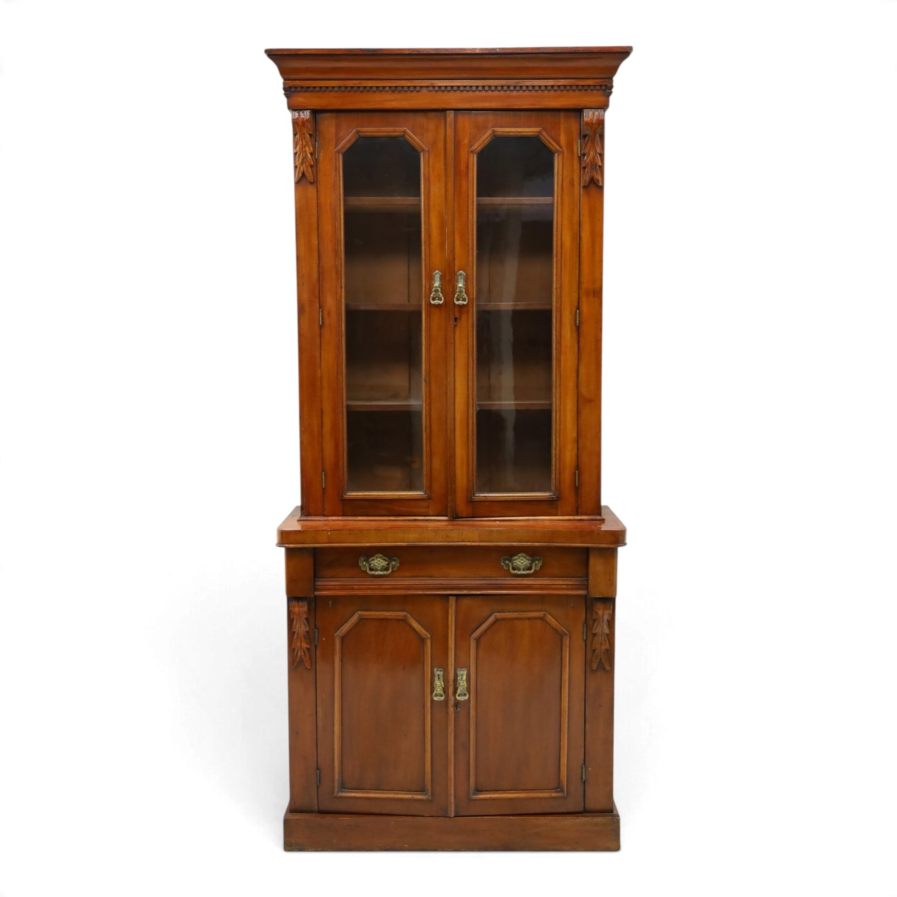 Victorian mahogany bookcase on cupboard of slender proportions, projecting cornice over dentil-frieze, fitted with twin-glazed doors enclosing three shelves, flanked by acanthus corbels, the base fitted with single frieze drawer over panelled cupboard, on skirted base