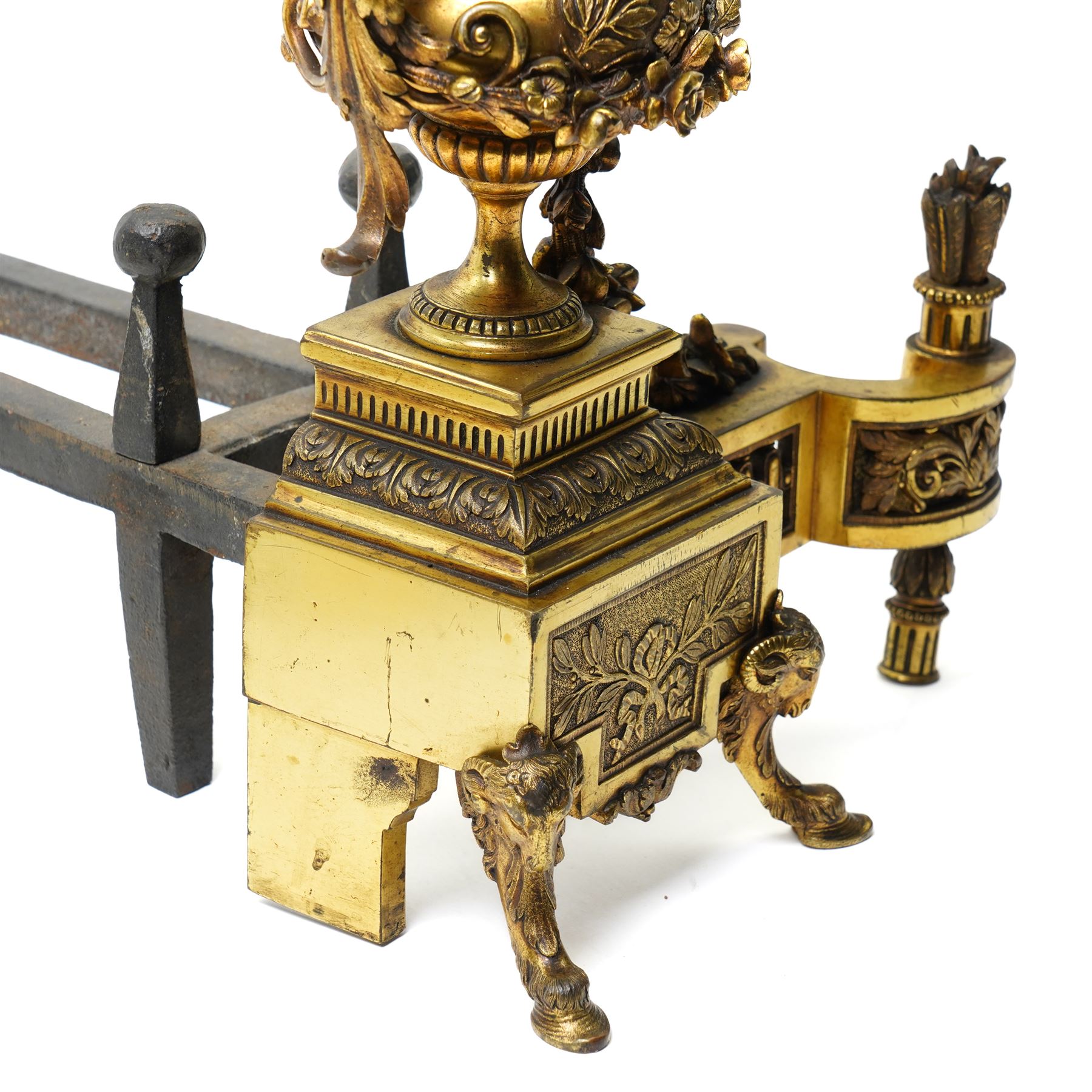 Pair of gilt metal fire dogs, formed as an urn with classical decoration, including putti and floral swags, raised on a square stepped base, the feet formed as rams heads and hoofs, H45cm x W28cm