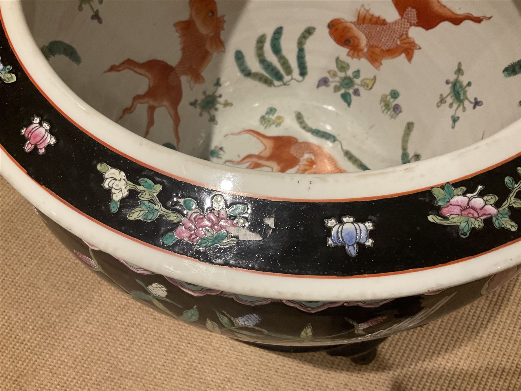 Large 20th century Chinese famille noir glazed porcelain jardinière, of ovoid form, the exterior enamelled with butterflies and white cranes amidst blossoming water lilies and pads against a black ground, between two stylised polychrome borders and beneath a key border to rim, the interior enamelled with red koi fish swimming amongst water fronds and weeds, with printed red character mark beneath, the whole upon an ebonised hardwood stand with three cabriole legs, jardinière H42cm D47cm, including stand overall H69.5cm