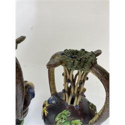 Pair of 19th century Portuguese Palissy style Majolica puzzle jugs, attributed to Manuel Mafra, with mossy rim and pierced lattice neck, twin handles in the form of snakes and the body decorated with frogs, lizards, and moths on a mottled brown glazed ground, unmarked, H20cm