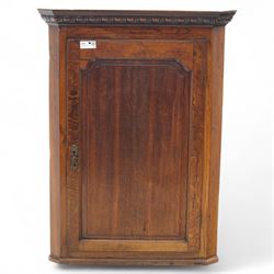 19th century oak wall hanging corner cupboard, moulded cornice above a panelled door enclosing shaped interior shelves, finished in green paint to the backboards