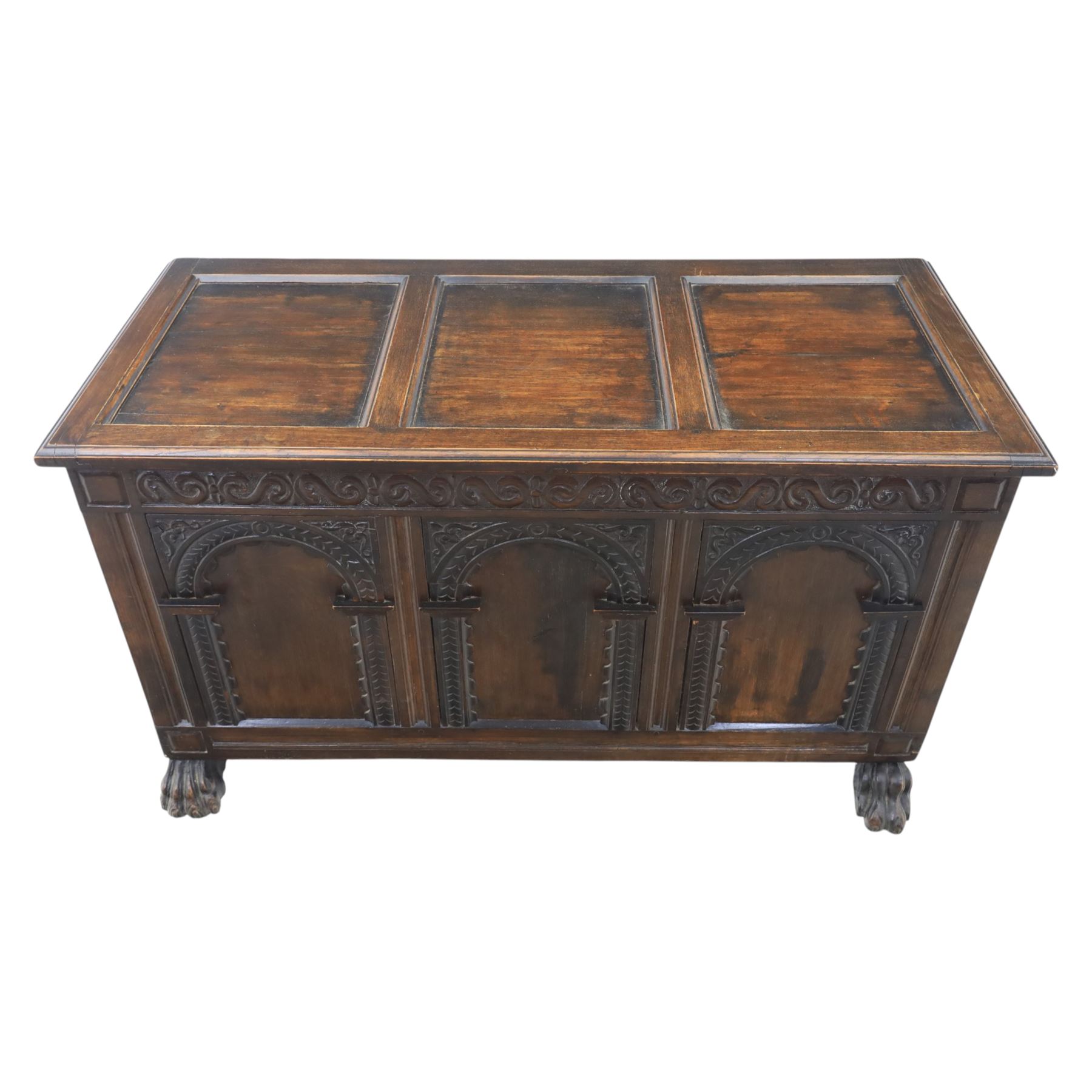 17th century design panelled oak blanket chest, hinged top above carved triple arch frieze, raised on individual carved claw feet