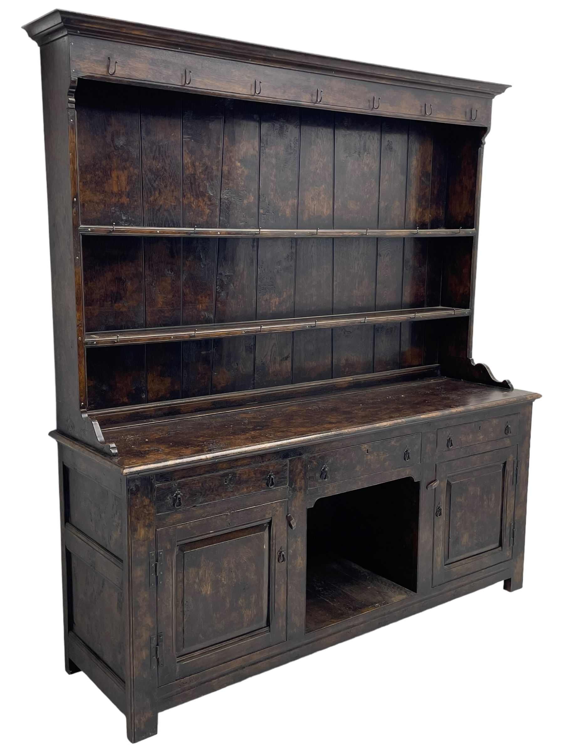 Bylaws of Leominster - 18th century design figured oak dog kennel dresser, the raised plate rack with projecting cornice over hooks and three tiers, moulded rectangular top over three drawers and two panelled cupboards, moulded frame and panelled sides, on stile supports