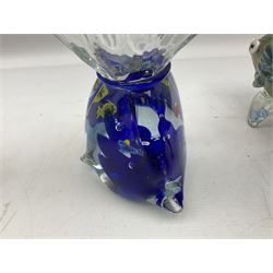 Two Murano stylised glass fish, each raised upon two clear fins, together with paperweight modelled as fish in a bag