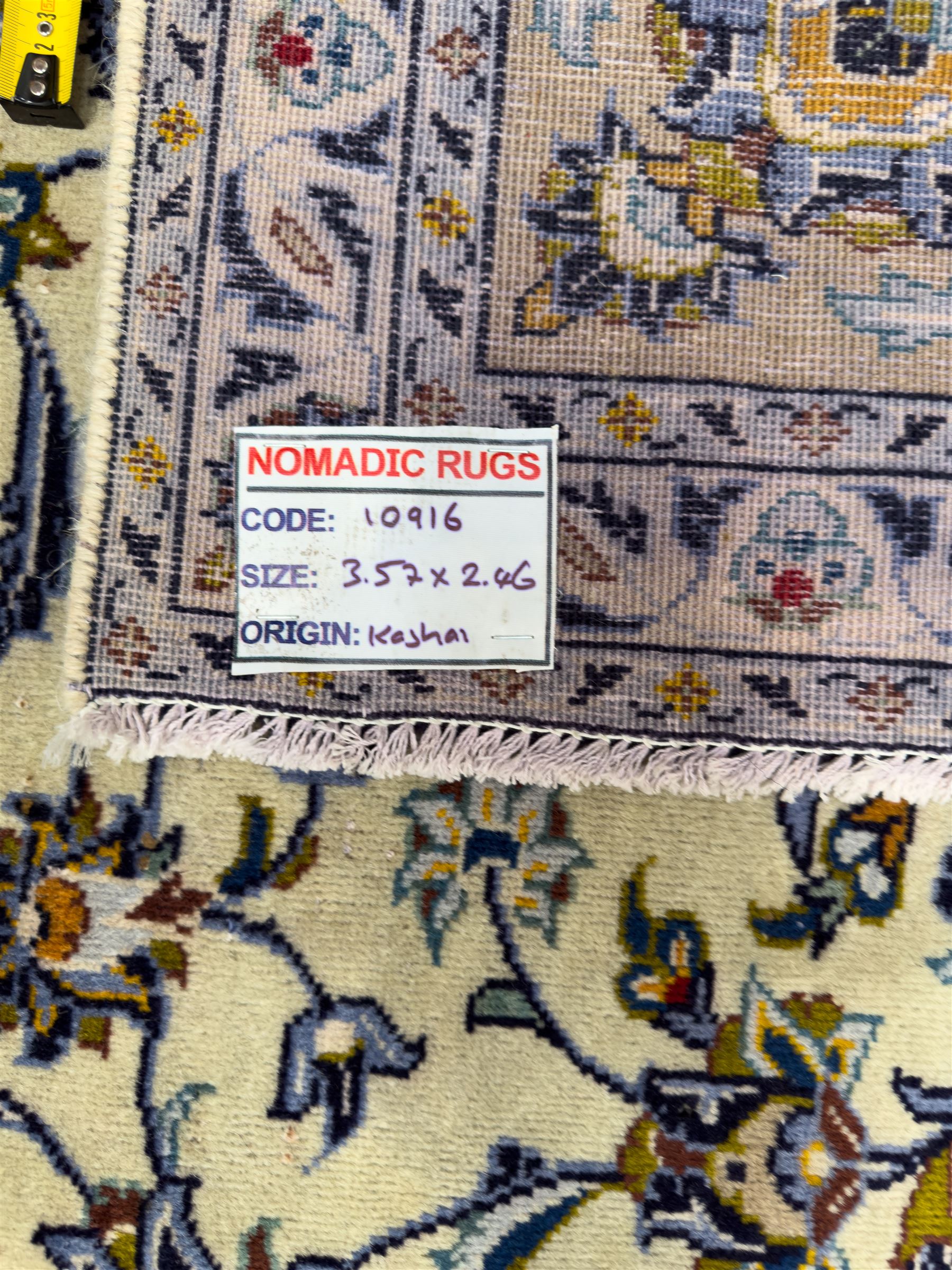 Central Persian Kashan hand-knotted carpet, ivory field with an all-over design of scrolling vines, lotus palmettes, and rosettes in shades of blue, gold, and brown within a blue ground border of palmettes and arabesques between multiple guard stripes