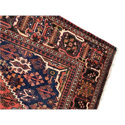 Persian Joshgan red ground rug, the medallion, field and spandrels decorated with clusters of Pitrak and tree of life motifs, the border with repeating design decorated with stylised plant motifs, within guard stripes