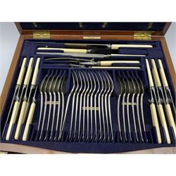 Late 19th/early 20th century composite canteen of silver flatware, contained within an early 20th century mahogany serpentine fronted case with twin drop carry handles, and hinged cover with boxwood stringing and central inlaid shell motif, above a single drawer with twin ring handles and Wellington style locking system, the cover and drawer opening to reveal plaque for Spink & Sons Ltd London, and fitted interior containing ivory handled knives, ivory handled carving set, and silver Hanoverian and Old English pattern cutlery, each with engraved monogram to terminal, hallmarked London, makers Spink & Son (John Marshall Spink), Goldsmiths & Silversmiths Co, and Chawner & Co (George William Adams), various dates ranging 1880-1923, gross weighable silver 92.59 ozt (2880 grams)