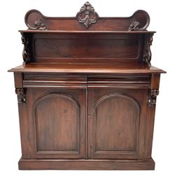 Victorian mahogany chiffonier, raised shaped back with foliage scroll carved mounts, on fretwork and carved bracket supports, moulded rectangular top over two frieze drawers and double panelled cupboard, on moulded plinth base