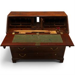 George III mahogany bureau of large proportions, the fall-front enclosing fitted interior with fluted column secret compartments and assorted pigeonholes and correspondence drawers flanking central cupboard, over four graduating cock-beaded drawers with original brass swan-neck handles, raised on bracket feet