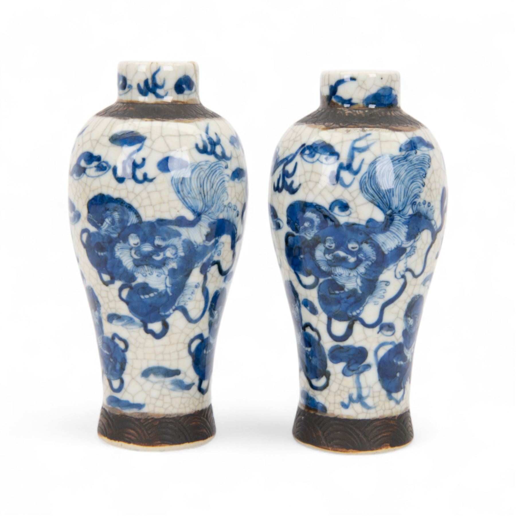 Pair of 20th century Chinese crackle glaze vases, of baluster form, decorated with dogs of foo amongst clouds, H23cm