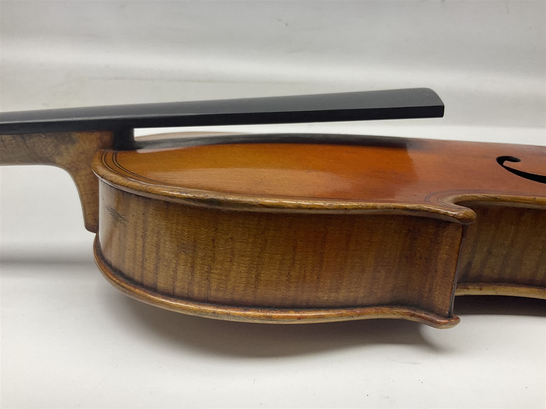 German trade violin c1900 copy of a Maggini with 36.5cm two-piece maple back and ribs and spruce top; double scroll; L60cm overall; in carrying case