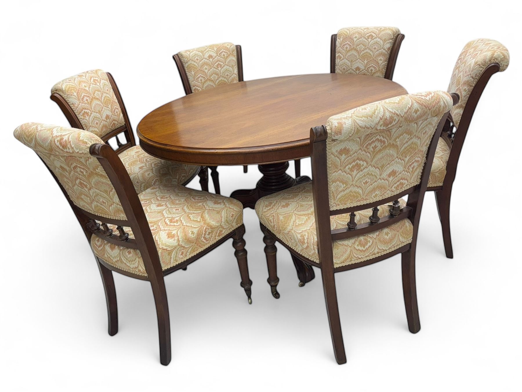 Victorian mahogany centre table, circular top above turned pedestal, terminating on three cabriole legs with scroll feet on porcelain castors, and six scroll carved upholstered dining chairs, with cushion and spindle turned backs, centre table  118x74cm, dining chairs 89x46x50cm