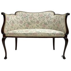 Early 20th century mahogany framed two seat salon settee, upholstered in floral pattern fabric, on cabriole supports