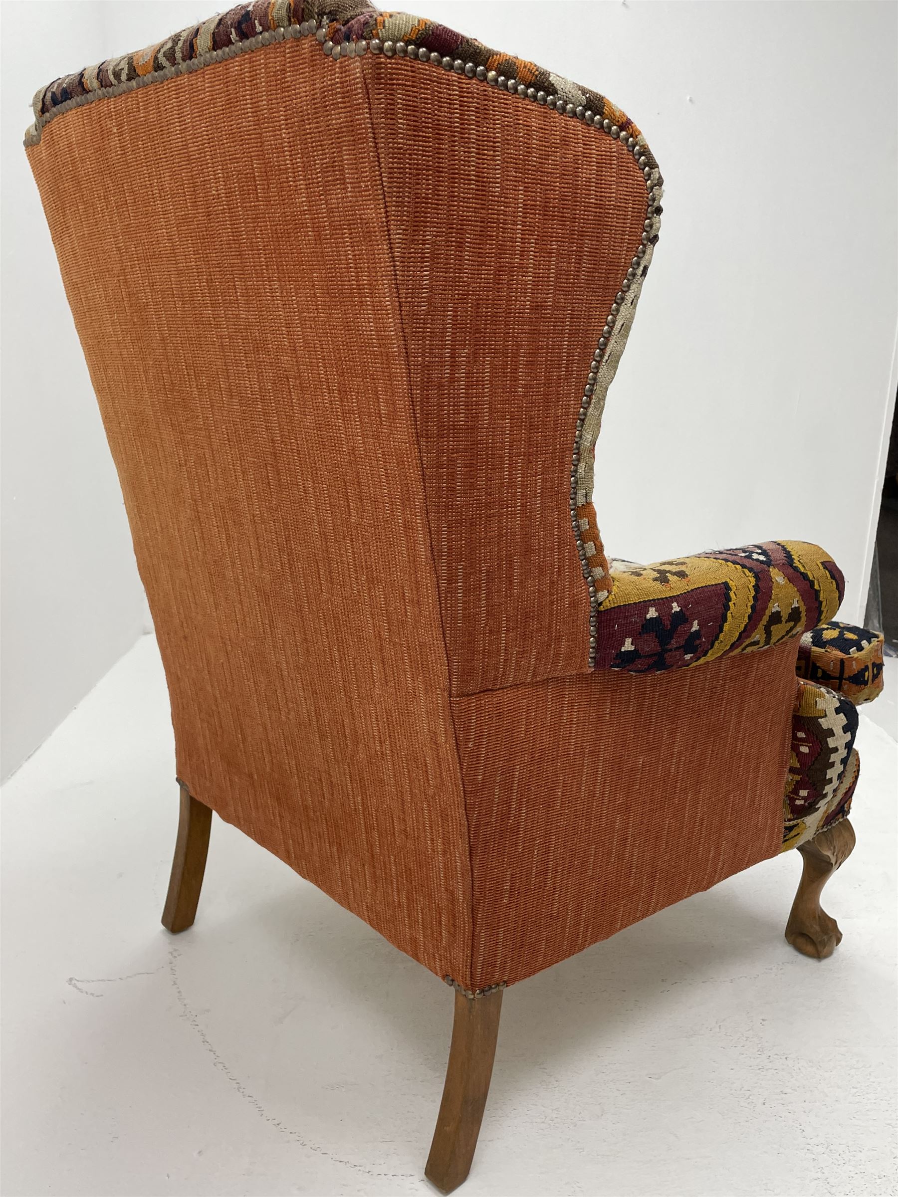 Late 20th century beech framed wingback armchair, sprung seat and back upholstered in kilim cover, acanthus carved cabriole supports with ball and claw feet