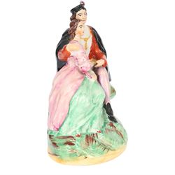 Rare Staffordshire pottery figure group, circa 1852, modelled as Romeo and Juliet, both seated upon a naturalistic base with their arms around one another, Romeo wearing cloak and plumed hat, Juliet in long dress, H20cm